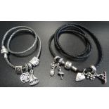 TWO PANDORA CHARM BRACELETS WITH CHARMS comprising a black woven triple bracelet and a silver/grey