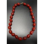 CHERRY AMBER BEAD NECKLACE approximately 45cm long; together with a large cherry amber loose bead,