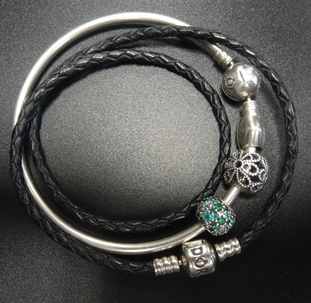 PANDORA MOMENTS SILVER BANGLE WITH STAR DECORATED CLASP and three charms; together with a black