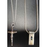TWO SILVER PENDANTS comprising a blue topaz set rectangular example and a cross pendant, both on