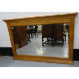 LIGHT OAK OVERMANTLE MIRROR with a bevelled plate in a moulded and carved oak frame, 98cm x 150cm