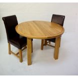 CIRCULAR LIGHT OAK EXTENDING DINING TABLE with a pull apart top revealing a fold out leaf,