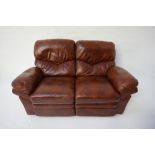 BROWN LEATHER TWO SEATER RECLINING SETTEE raised on small feet, 164cm wide