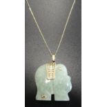 CARVED JADE PENDANT in the form of a stylised elephant with nine carat gold mount and on fine nine