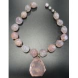 ROSE QUARTZ BEAD NECKLACE the beads of irregular form, 43cm long, together with a large rose