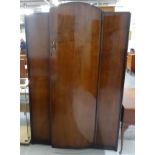 1930'S MAHOGANY BOW FRONT WARDROBE with a central arched door opening to reveal hanging rails and