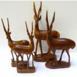 FOUR CARVED AFRICAN HARDWOOD IMPALAS all on a plinth base, three with a calf to foot (4)