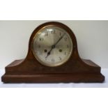 NAPOLEAN HAT WALNUT MANTLE CLOCK with a circular silvered dial with Arabic numerals and an eight day