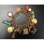 NINE CARAT GOLD CURB LINK CHARM BRACELET with a good selection of gold and other charms, including