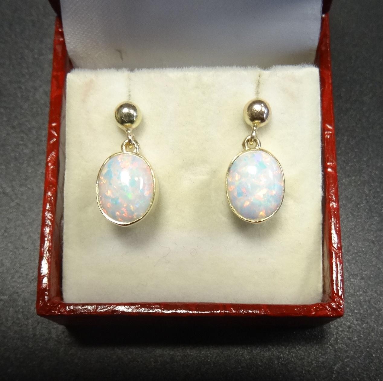 PAIR OF OPAL DROP EARRINGS the oval cabochon opals in nine carat gold settings