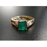 EMERALD AND DIAMOND DRESS RING the central emerald cut emerald approximately 0.85cts flanked by four