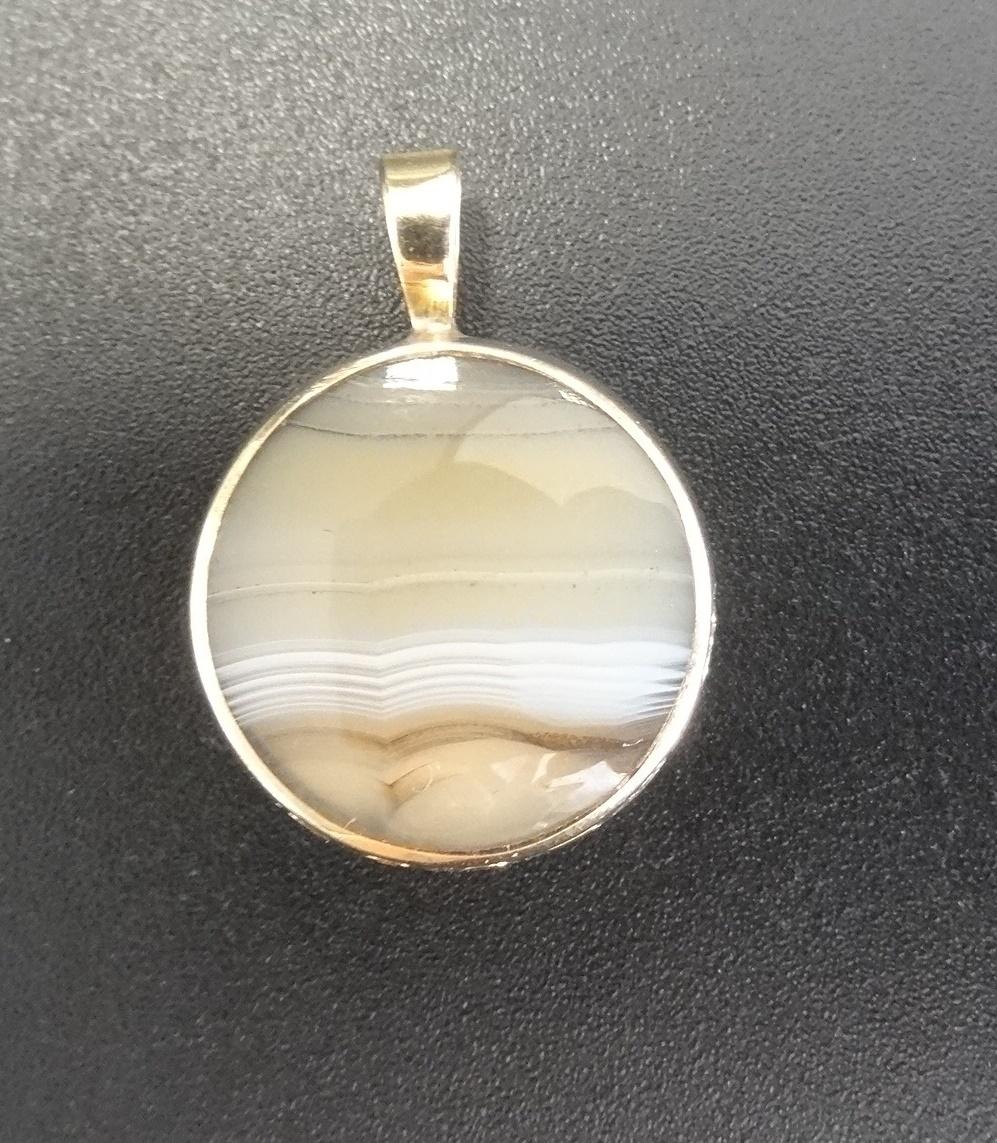 A DOUBLE SIDED AGATE SET FOB in nine carat gold mount