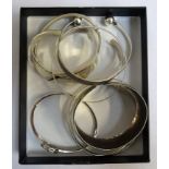 EIGHT SILVER BANGLES including one with pierced crystal set tree decoration, another with ball