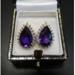PAIR OF AMETHYST AND DIAMOND CLUSTER EARRINGS the central pear cut amethyst on each in illusion