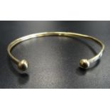 NINE CARAT GOLD BANGLE with ball finials, approximately 2.4 grams