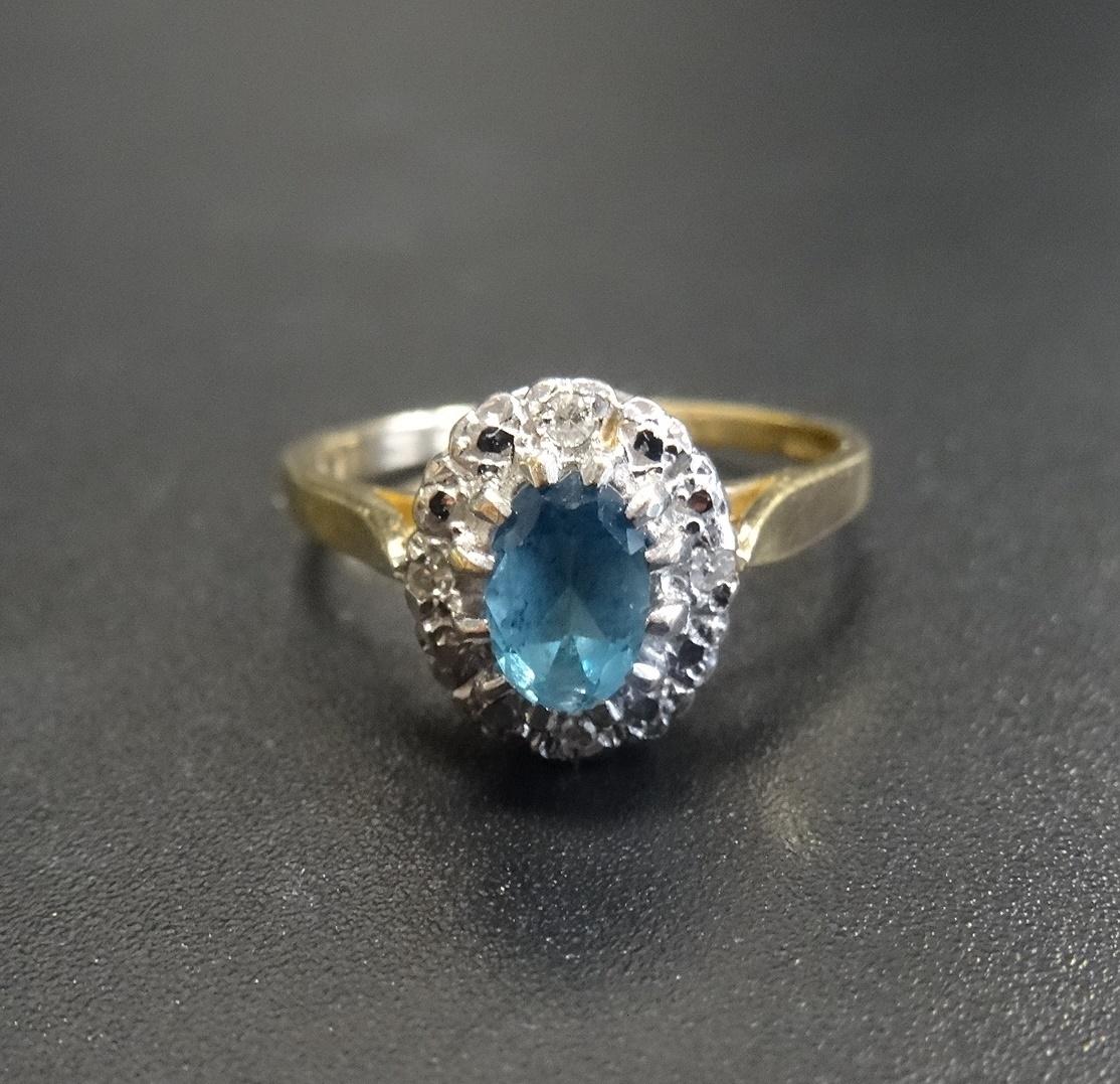 BLUE TOPAZ AND DIAMOND CLUSTER RING the central oval cut blue topaz with small diamonds to the