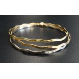 EIGHTEEN CARAT GOLD RUSSIAN WEDDING RING STYLE TRIPLE BANGLE comprising wavy white, yellow and