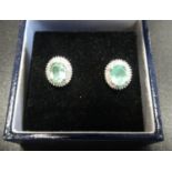 ATTRACTIVE PAIR OF GREEN GEM AND DIAMOND CLUSTER EARRINGS the central oval cut stones possibly green