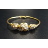 TWENTY-TWO CARAT GOLD CHILD'S BRACELET with crystal decoration, 4.4cm diameter, total weight