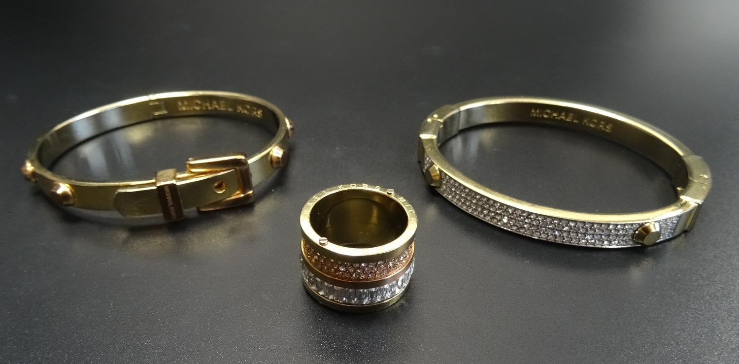 SELECTION OF MICHAEL KORS JEWELLERY comprising two bangles, one pave set and another of buckle