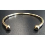 NINE CARAT GOLD BANGLE with ball finials, approximately 11.7 grams