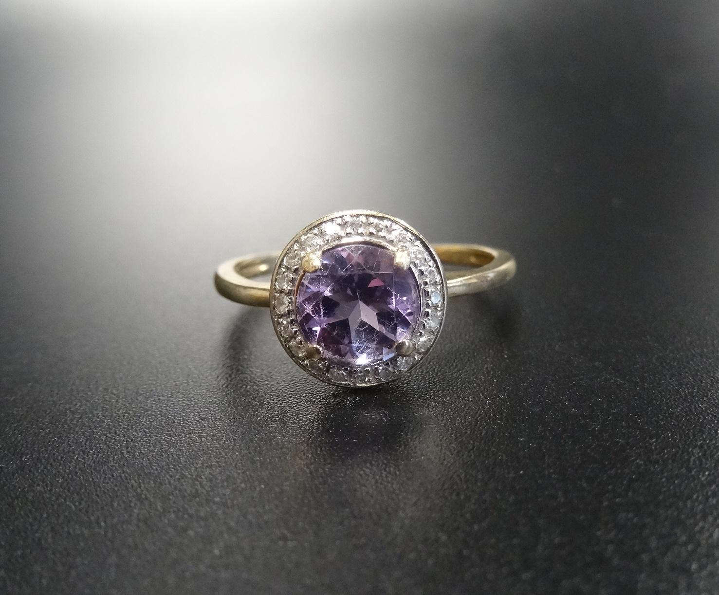 AMETHYST AND DIAMOND CLUSTER RING the central round brilliant cut amethyst in twenty diamond