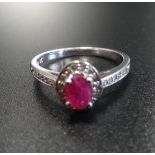 RUBY AND DIAMOND CLUSTER RING the central ruby in diamond surround and with further diamonds to