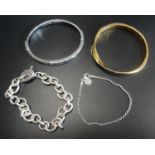 THREE FASHION BRACELETS comprising a Michael Kors Logo plaque and crystal set silver tone bangle,