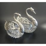 TWO GRADUATED SILVER MOUNTED CUT GLASS TABLE SALTS in the form of swans with articulated pierced