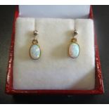 PAIR OF OPAL DROP EARRINGS the oval cabochon opals in nine carat gold