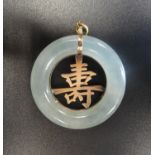 JADE AND TEN CARAT GOLD PENDANT the outer ring of jade with gold Chinese character to the centre,