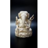 CARVED INDIAN IVORY FIGURE OF GANESH early 20th century, seated with a rat looking up at him, 10cm