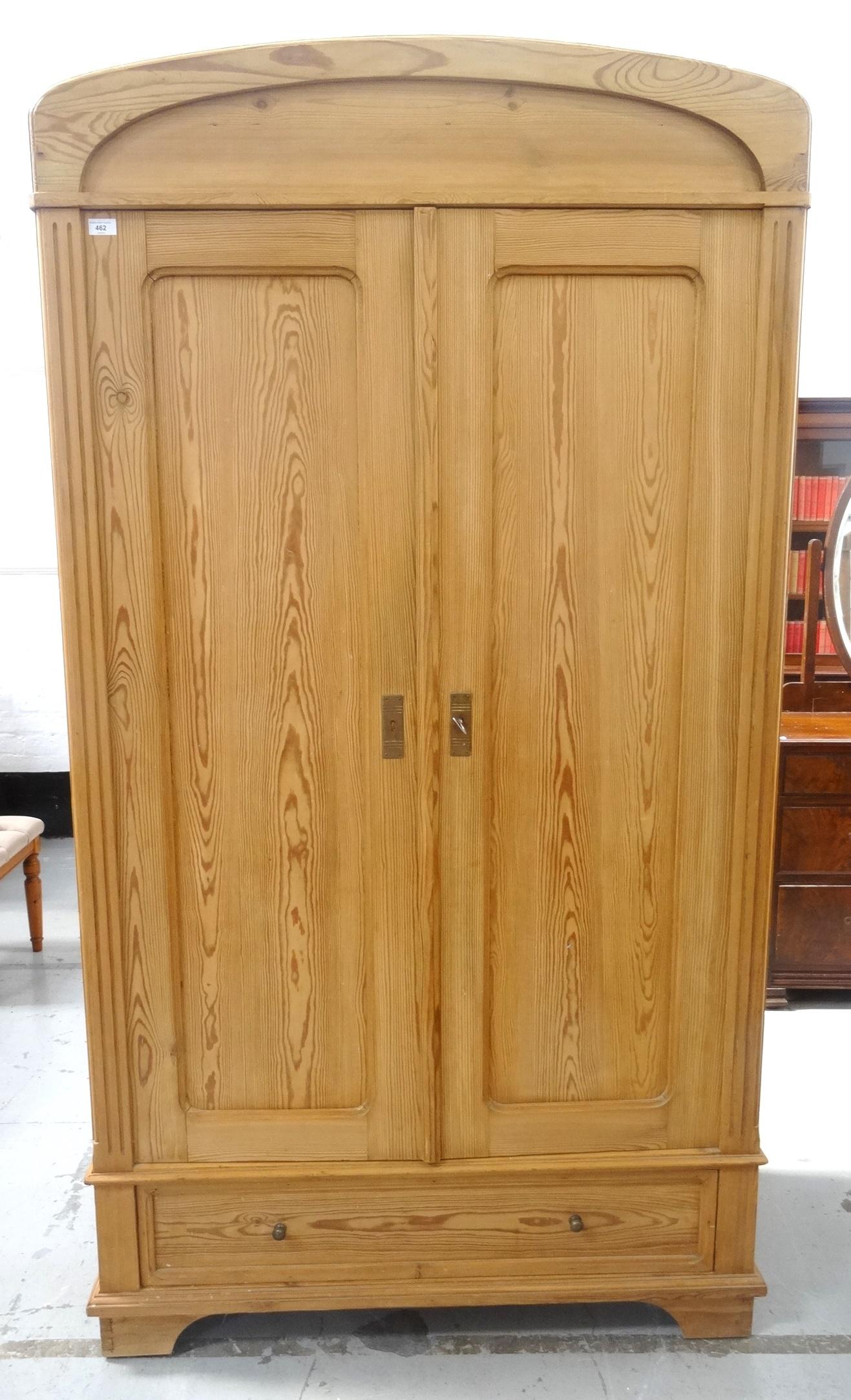 WAXED PINE WARDROBE the arched top above a pair of panelled doors opening to reveal a shelf and