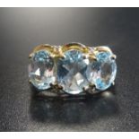 AQUAMARINE AND DIAMOND DRESS RING the three oval cut aquamarines with two small diamonds above and