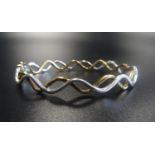 NINE CARAT GOLD WAVY DESIGN BRACELET in white and yellow gold, approximately 10.4 grams