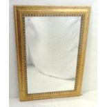 GILTWOOD FRAME MIRROR with ripple decoration around a bevelled plate, 107.5cm x 78.5cm