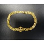 TWENTY-ONE CARAT GOLD BRACELET the central pierced diamond shaped section flanked by the fancy