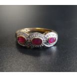 RUBY AND DIAMOND DRESS RING the three oval cut rubies in textured surround set with small