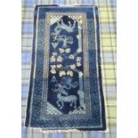 20th CENTURY CHINESE RUG the blue ground decorated with deer and birds by a tree, encased in a