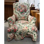 MID VICTORIAN ARMCHAIR with outswept arms and covered in a later floral fabric, standing on turned