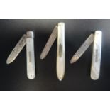 THREE VICTORIAN MOTHER OF PEARL HANDLED SILVER BLADED FRUIT KNIVES all with engraved blades, with