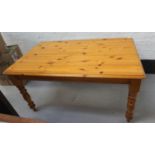 WAXED PINE FARMHOUSE STYLE TABLE with a moulded top, standing on turned supports, 151cm wide