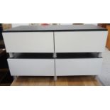 TWO LOW STAINED WOOD SIDE CABINETS both with two frieze drawers, standing on turned aluminium