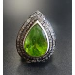 UNUSUAL PERIDOT AND DIAMOND CLUSTER RING the large central pear cut peridot approximately 7.5cts