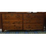 LARGE PINE EFFECT CHEST with an arrangement of six drawers, standing on plain supports, 155cm long