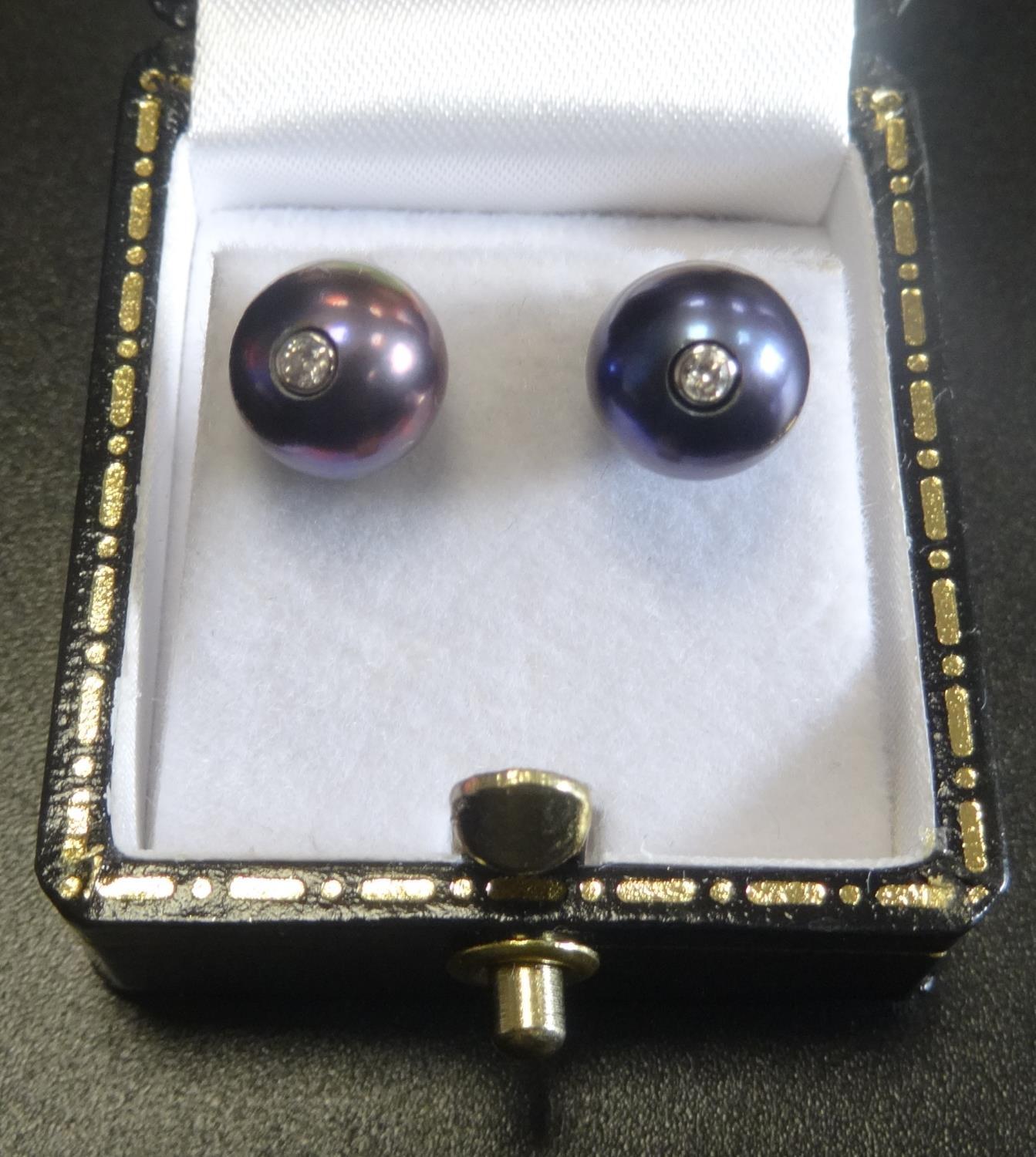 UNUSUAL PAIR OF BLACK PEARL AND DIAMOND STUD EARRINGS the diamond set posts to the centre of each