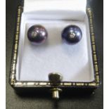 UNUSUAL PAIR OF BLACK PEARL AND DIAMOND STUD EARRINGS the diamond set posts to the centre of each