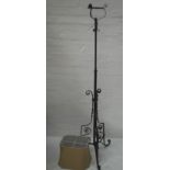 PAINTED WROUGHT IRON ADJUSTABLE LAMP STAND raised on three scroll supports with applied flower