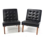 A PAIR OF LEATHER SLIPPER CHAIRS featuring buttoned upholstery and standing on teak effect