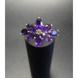 AMETHYST AND DIAMOND CLUSTER RING the oval cut amethyst cluster around a small central diamond, on